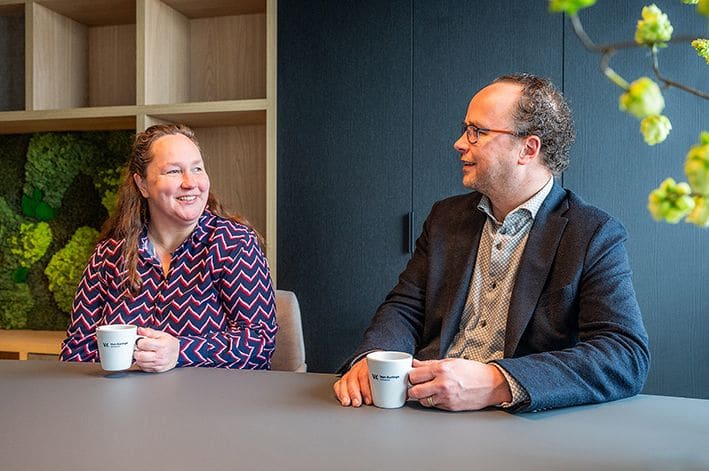 Twee collega’s van Van Kuringe in gesprek op kantoor